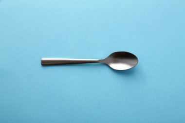 Dessert spoon on blue background clipart