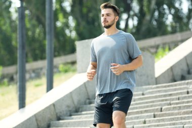 Genç adam açık havada merdivenlerde koşma