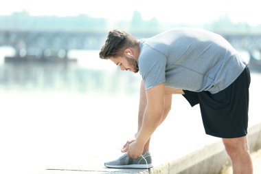 Sportif adam açık havada ayakkabı bağcığı bağlama