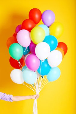 Birçok renkli balon tutan kadın