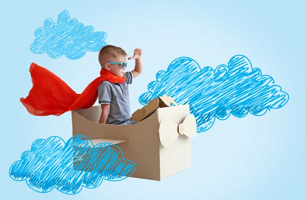 Menino brincando com avião de papelão — Fotografia de Stock