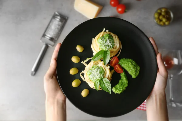 Женщина держит вкусные Tagliatelle макароны с ингредиентами, вид сверху — стоковое фото