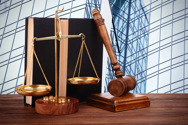 Gavel with books and scales on modern skyscraper background — Stockfoto