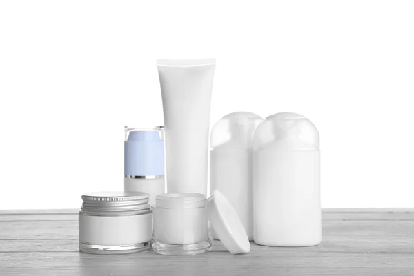 Different cosmetic bottles on table on white background — Stock Photo, Image