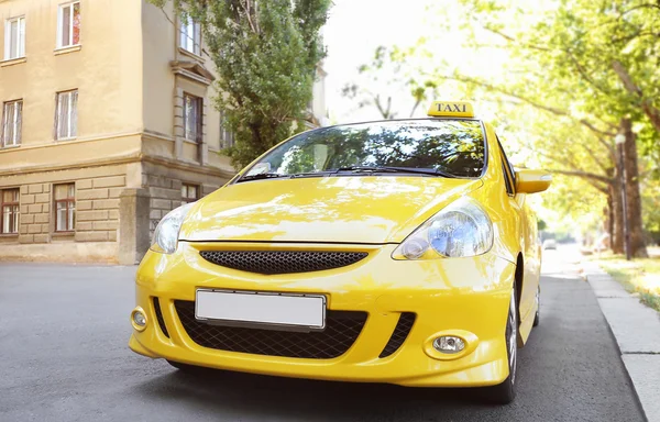 Желтый автомобиль такси на городской дороге — стоковое фото