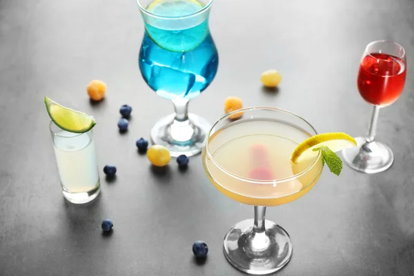 Leckere Cocktails mit süßen Beeren auf grauem Tisch — Stockfoto