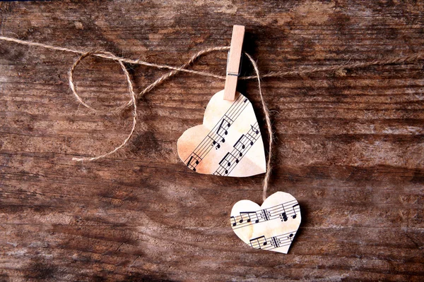 Corações de papel com notas de música em fundo de madeira — Fotografia de Stock