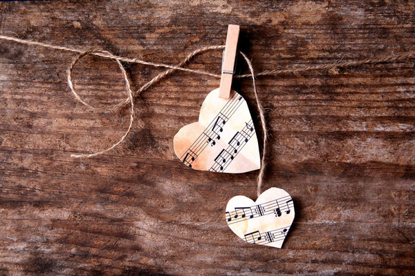 Paper hearts with music notes on wooden background