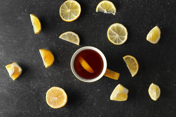 Cup of fresh tea with slices of lemons around, top view — Stock Photo, Image