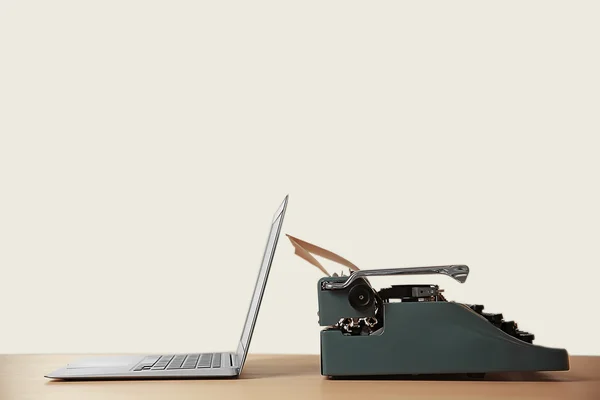 Oude schrijfmachine en laptop op tafel. Concept van vooruitgang van de technologie — Stockfoto