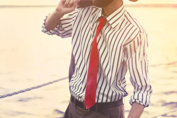 Çizgili gömlekli kravatli kırmızı deri bir iskelede adam — Stok fotoğraf