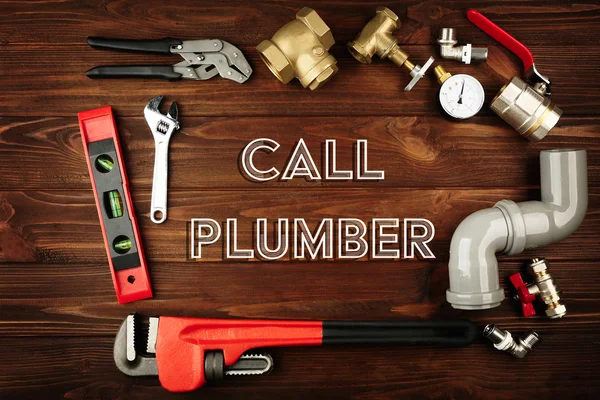 Call Plumber. Plumber tools frame on wooden background — Stock fotografie
