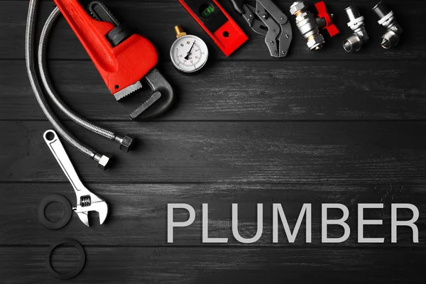 Plumbing concept. Plumber tools on a gray wooden background — Stockfoto