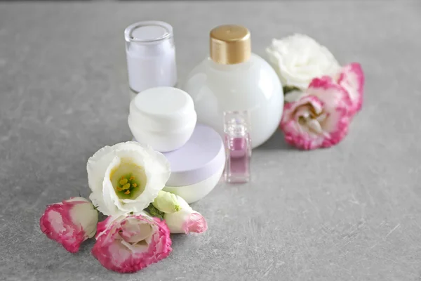 Kozmetik Şişeler ve eustoma açık ahşap renkli çiçekleri — Stok fotoğraf