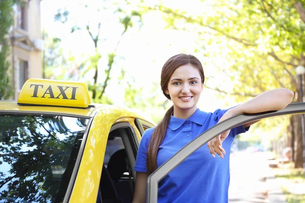 Piękne kobiece taksówkarz stojący w pobliżu samochodu — Zdjęcie stockowe
