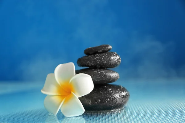 Pedras de spa com flor de plumeria — Fotografia de Stock