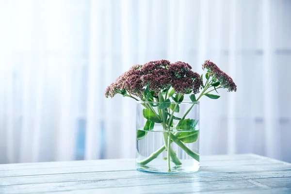 Vas med bukett med vackra blommor på bord — Stockfoto