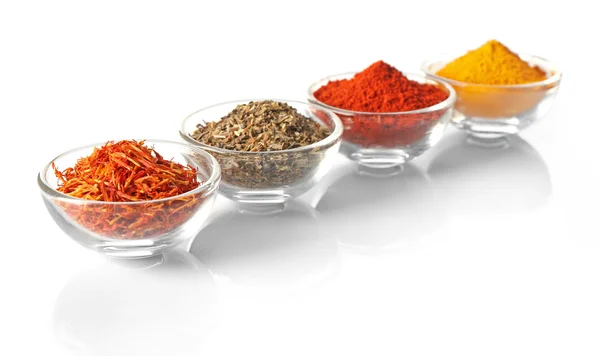 Glass bowls with different spices in a row on white background — Stock Photo, Image