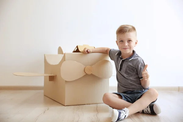 Kleiner Junge spielt mit Pappflugzeug — Stockfoto