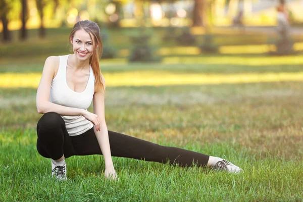 Ung kvinna Stretching utomhus — Stockfoto