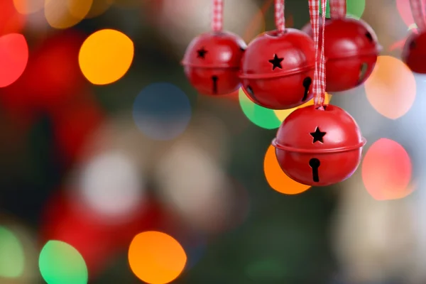 Sinos jingle em luzes de Natal borradas fundo, close-up — Fotografia de Stock