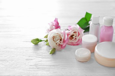 Kozmetik Şişeler ve eustoma açık ahşap renkli çiçekleri