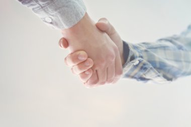 Erkekler tokalaşırken ışık arka plan üzerinde