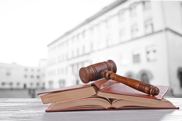 Judge's gavel and books on blurred building background — Stock Photo, Image
