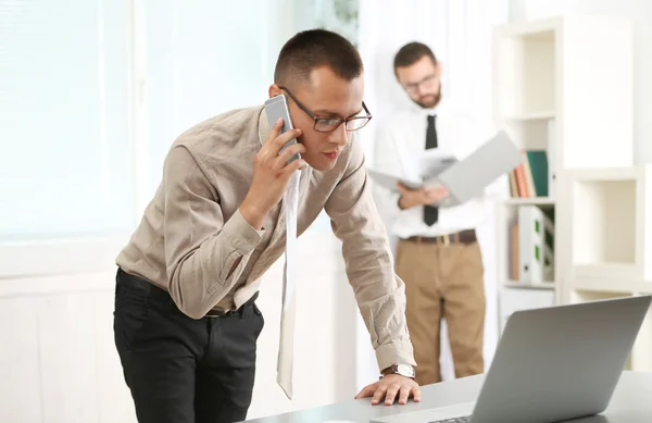 Uomo Affari Che Parla Smartphone Guarda Computer Portatile Ufficio — Foto Stock