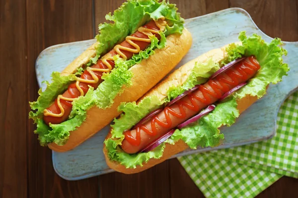 Pyszne hot dogi na desce — Zdjęcie stockowe
