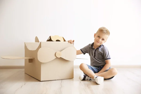 Мальчик играет с картонным самолетом — стоковое фото