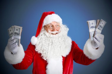 Noel Baba para mavi arka plan üzerinde tutan