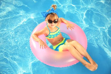 Güneşli yüzme havuzunda küçük kız