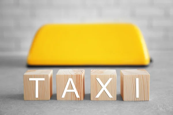 Kockák szó taxi és a tető alá a téglafal háttér — Stock Fotó