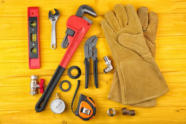 Loodgieter tools op gele houten achtergrond — Stockfoto