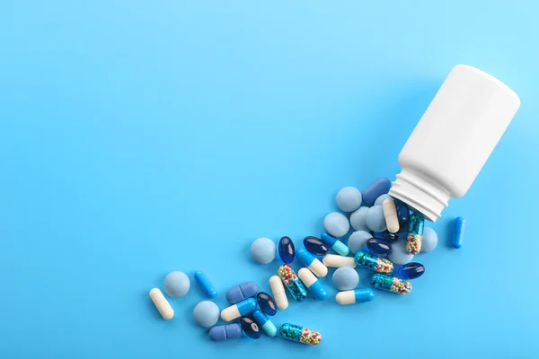 Haufen Pillen auf blauem Hintergrund — Stockfoto