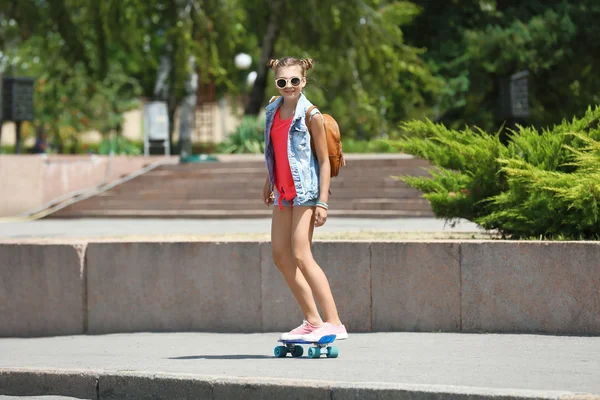 Jong meisje paardrijden skateboard — Stockfoto
