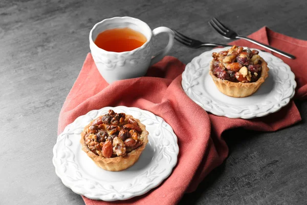 Tazza di tè e gustose crostate sul tavolo — Foto Stock