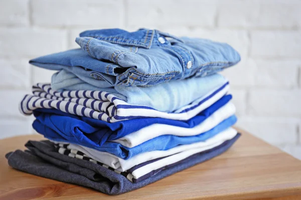 Pile of clothes on wooden stool, closeup