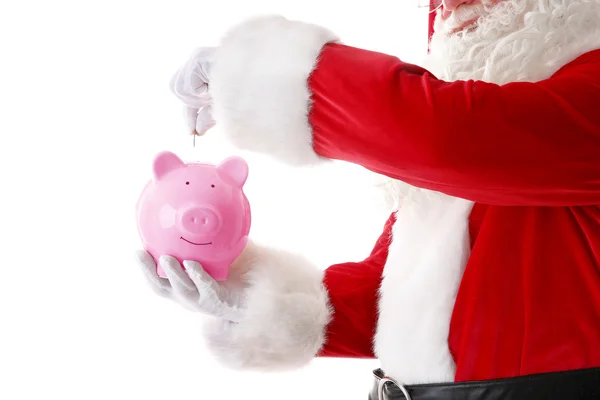 Санта Клаус кладет монету в копилку на белом фоне — стоковое фото