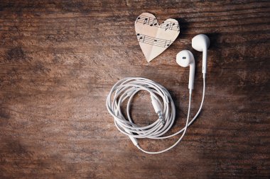 Kağıt kalpler müzik notlar ve ahşap arka plan üzerinde kulaklık