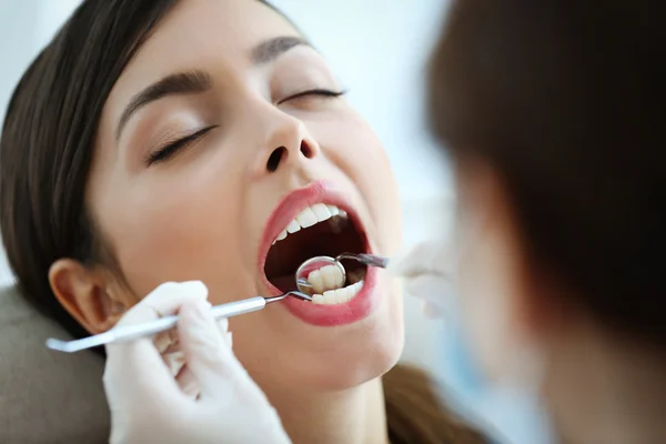 Dentist examining patient's teeth — Stock Photo, Image