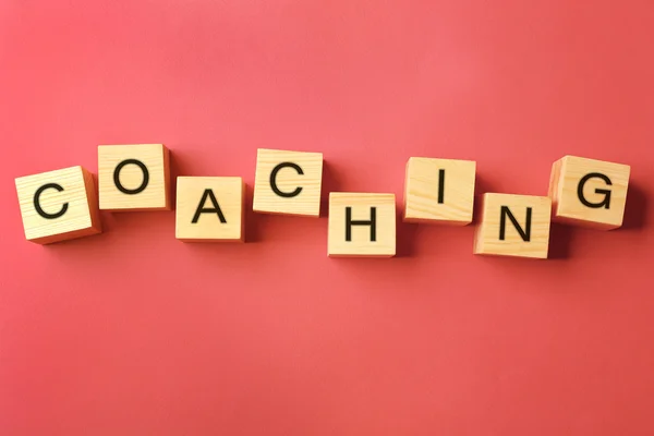 Coaching concept. Houten kubussen op roze achtergrond — Stockfoto