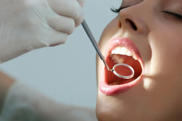 Dentist examining patient's teeth — Stock Photo, Image