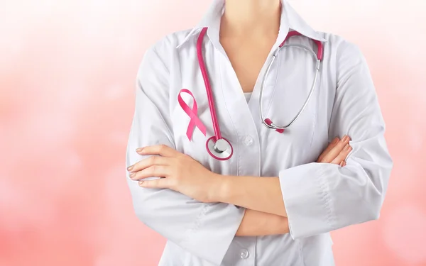 Female doctor with pink ribbon on chest — Stock Photo, Image