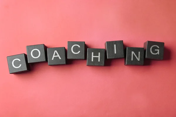 Coaching concept. Houten kubussen op roze achtergrond — Stockfoto