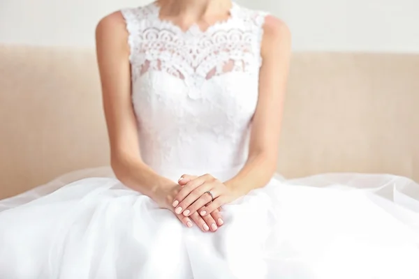 Brud i vackra brudklänning sitter på soffa — Stockfoto