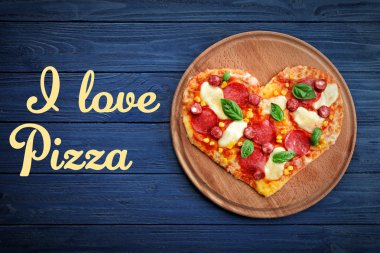 Ahşap arka plan üzerinde kalp şeklinde pizzayla plaka