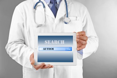 Tablet gri arka plan üzerinde profesyonel doktorla. Çocuk otizm kavramı