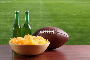 Rugby topu, cips ve bira yeşil alan arka plan üzerinde